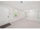 Spacious living room with a door, neutral walls, and carpet, offering plenty of natural light from windows at 171 Riverview Trl, Roswell, GA 30075