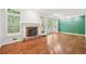 Bright living room with hardwood floors, fireplace, and natural light from large windows at 171 Riverview Trl, Roswell, GA 30075