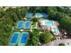 Aerial view of a community featuring tennis courts, a swimming pool, and lush landscaping, offering resort-style living at 8935 Muirfield Ct, Duluth, GA 30097