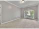 Comfortable bedroom featuring large window with backyard views, neutral walls and carpet floors at 8935 Muirfield Ct, Duluth, GA 30097