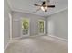 Cozy bedroom featuring a ceiling fan, neutral walls and carpet floors with access to a balcony at 8935 Muirfield Ct, Duluth, GA 30097