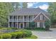 Elegant two-story brick home showcasing a manicured lawn, mature trees, and welcoming curb appeal at 8935 Muirfield Ct, Duluth, GA 30097