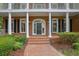 Inviting entryway boasting a classic brick facade, arched doorway, and manicured shrubbery at 8935 Muirfield Ct, Duluth, GA 30097