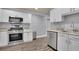 Well-equipped kitchen featuring stainless steel appliances and bright white cabinets at 8935 Muirfield Ct, Duluth, GA 30097