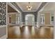 Spacious living room showcasing beautiful hardwood floors, elegant wallpaper, and ample natural light at 8935 Muirfield Ct, Duluth, GA 30097