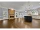 Open living room featuring a stone fireplace, hardwood floors, kitchen island and abundant natural light at 8935 Muirfield Ct, Duluth, GA 30097