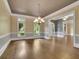 Sunlit living room featuring hardwood floors, and a modern chandelier at 8935 Muirfield Ct, Duluth, GA 30097
