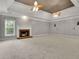 Spacious living room featuring a fireplace, ceiling fans, and a tray ceiling at 8935 Muirfield Ct, Duluth, GA 30097