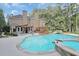 Backyard oasis features a swimming pool, waterfalls, patio, and lush landscaping at 8935 Muirfield Ct, Duluth, GA 30097