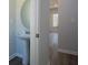 Stylish powder room featuring a pedestal sink, round mirror, and neutral paint at 250 Shawnee Trl, Dallas, GA 30157