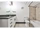 Modern bathroom features granite countertops, sleek white cabinetry, and a combined shower and tub at 1261 Caroline St # 211, Atlanta, GA 30307