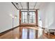 A spacious living room features large windows, brick accents, and hardwood floors, providing ample natural light at 1261 Caroline St # 211, Atlanta, GA 30307