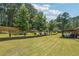Lush backyard featuring a covered outdoor kitchen/dining area, a retaining wall, and established landscaping at 1369 Sierra Ridge Pl, Loganville, GA 30052