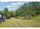Expansive backyard features a covered outdoor kitchen and dining area with a lush green lawn at 1369 Sierra Ridge Pl, Loganville, GA 30052