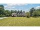Beautiful home with a large front lawn, complemented by mature trees and a long driveway at 1369 Sierra Ridge Pl, Loganville, GA 30052
