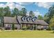 Charming brick home features a long, covered front porch, dormer windows and a lush green lawn at 1369 Sierra Ridge Pl, Loganville, GA 30052