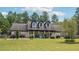 Inviting home showcases a well-manicured lawn, dormer windows and a long porch with column supports at 1369 Sierra Ridge Pl, Loganville, GA 30052