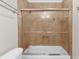 Bathroom featuring a white tub with glass doors and tiled walls at 1822 N Rock Springs Ne Rd # 24, Atlanta, GA 30324
