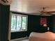 Cozy bedroom features an ceiling fan, green accent walls, and a serene ambiance with a window overlooking the greenery outside at 5015 Wright Bridge Rd, Cumming, GA 30028