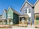 Colorful new construction townhomes with individual front porches and modern design elements, set against a clear blue sky at 1095 Tucker Ave # 401, Atlanta, GA 30310