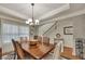 A dining room with a large table, decorative rug, and view of the staircase at 236 Creek View Ln, Acworth, GA 30102