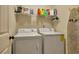 Functional laundry room featuring a washer and dryer with storage on a wire rack above at 236 Creek View Ln, Acworth, GA 30102