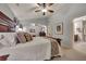 Bright main bedroom featuring a patterned bedspread, ceiling fan, and ensuite bathroom at 236 Creek View Ln, Acworth, GA 30102