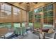 Light-filled sunroom with multiple windows and comfortable seating, overlooking a landscaped backyard at 236 Creek View Ln, Acworth, GA 30102