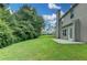 Expansive backyard featuring a lush green lawn, mature trees, and a patio adjacent to the home at 2421 Fall Creek Lndg, Loganville, GA 30052