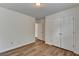 A clean and tidy bedroom showcasing wood-look flooring, fresh white walls, and a double-door closet at 2421 Fall Creek Lndg, Loganville, GA 30052