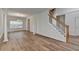 Open dining room featuring hardwood floors, bright natural light, and stairs leading upstairs at 2421 Fall Creek Lndg, Loganville, GA 30052