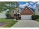 Charming two-story home featuring a brick facade, attached two-car garage, and well-manicured lawn at 2421 Fall Creek Lndg, Loganville, GA 30052