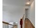 Well-lit hallway with wood flooring and classic wooden banister at 2421 Fall Creek Lndg, Loganville, GA 30052