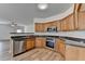 Well-lit kitchen with stainless steel appliances, wooden cabinets, and hardwood floors at 2421 Fall Creek Lndg, Loganville, GA 30052