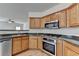 Modern kitchen with stainless steel dishwasher, oven, and wood cabinets at 2421 Fall Creek Lndg, Loganville, GA 30052