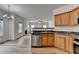 Open-concept kitchen featuring stainless steel dishwasher and view into living area at 2421 Fall Creek Lndg, Loganville, GA 30052