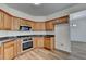 Updated kitchen showcases stainless steel appliances, wood cabinets, and adjacent dining space at 2421 Fall Creek Lndg, Loganville, GA 30052