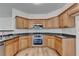 Well-lit kitchen featuring granite countertops, stainless steel appliances, and wooden cabinets at 2421 Fall Creek Lndg, Loganville, GA 30052