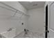 Laundry room boasts stylish gray floors, shelving, utility sink, and convenient access door at 2421 Fall Creek Lndg, Loganville, GA 30052