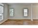 Bright living room featuring laminate floors, large windows, and classic crown molding at 2421 Fall Creek Lndg, Loganville, GA 30052