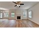 Bright living room with wood flooring, a ceiling fan, a fireplace, and many windows at 2421 Fall Creek Lndg, Loganville, GA 30052