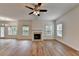 Bright living room with wood flooring, a ceiling fan, a fireplace, and many windows at 2421 Fall Creek Lndg, Loganville, GA 30052