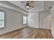 Main bedroom showing a tray ceiling, ceiling fan, wood-look flooring, and natural light from two windows at 2421 Fall Creek Lndg, Loganville, GA 30052