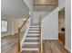 Staircase with wood railing and laminate floors leading to the upper level, offering an open and airy feel at 2421 Fall Creek Lndg, Loganville, GA 30052