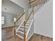 Staircase with wood railing and laminate floors leading to the upper level, offering an open and airy feel at 2421 Fall Creek Lndg, Loganville, GA 30052