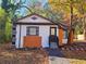 Charming cottage-style home featuring fall foliage and a cozy entryway, freshly landscaped at 2977 5Th St, Atlanta, GA 30315