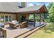 Inviting outdoor deck with wicker furniture, dining table, and scenic views of the lake and landscaped yard at 1005 Renfroe Lake Dr, Auburn, GA 30011