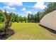 Expansive backyard featuring a manicured lawn, trees, shrubs, and tasteful landscaping for outdoor enjoyment at 1005 Renfroe Lake Dr, Auburn, GA 30011