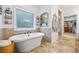 Bathroom showcasing a stand-alone tub and a decorative mirror with access to a walk-in closet at 1005 Renfroe Lake Dr, Auburn, GA 30011