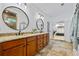 Double vanity bathroom featuring granite countertops and decorative mirrors with a view to the main bedroom at 1005 Renfroe Lake Dr, Auburn, GA 30011